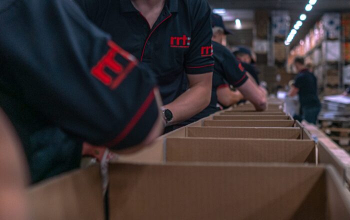 Body shot of people in uniforms packing boxes
