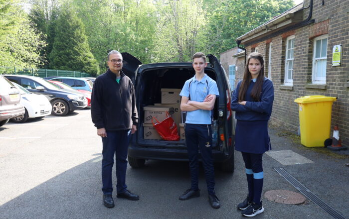 Boy and girl in front of a van full of boxes with man