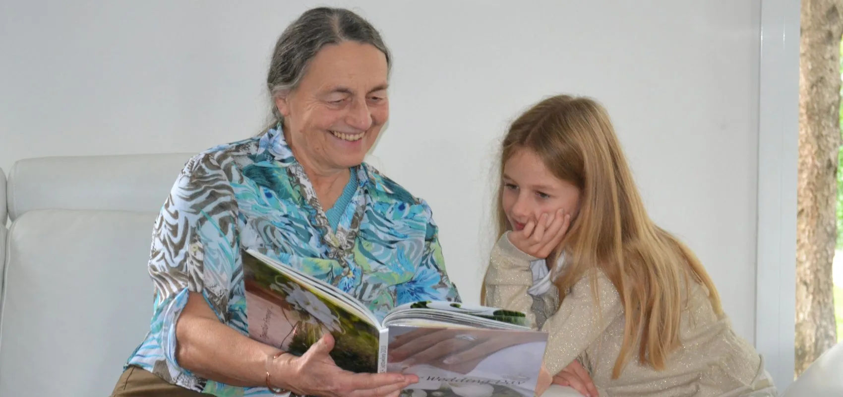 Young girl reading with elderly woman